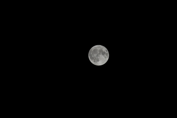 Bright zoomed in shot of the full moon, in focus